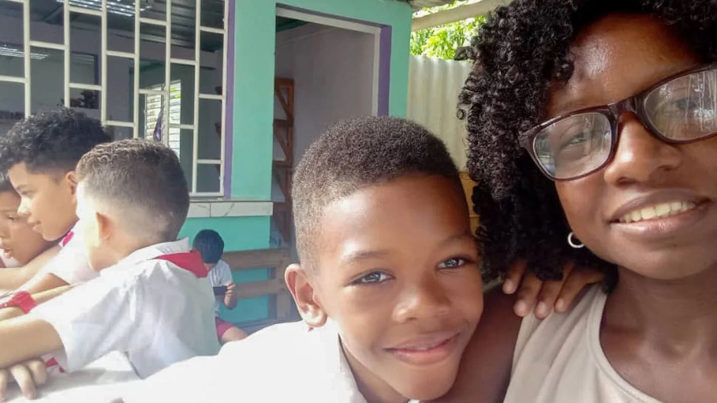 Mulher sorri abraçada a uma criança em ambiente doméstico em Havana, foto de arquivo usada para ilustrar o cotidiano cubano sob os apagões