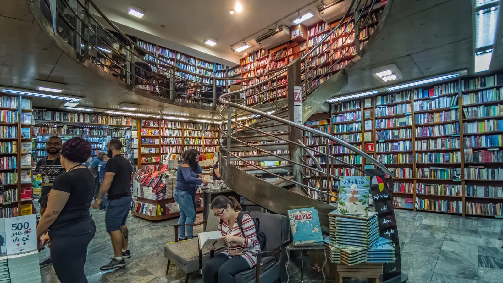 Interior da Livraria Martins Fontes em São Paulo, com clientes e escada em espiral