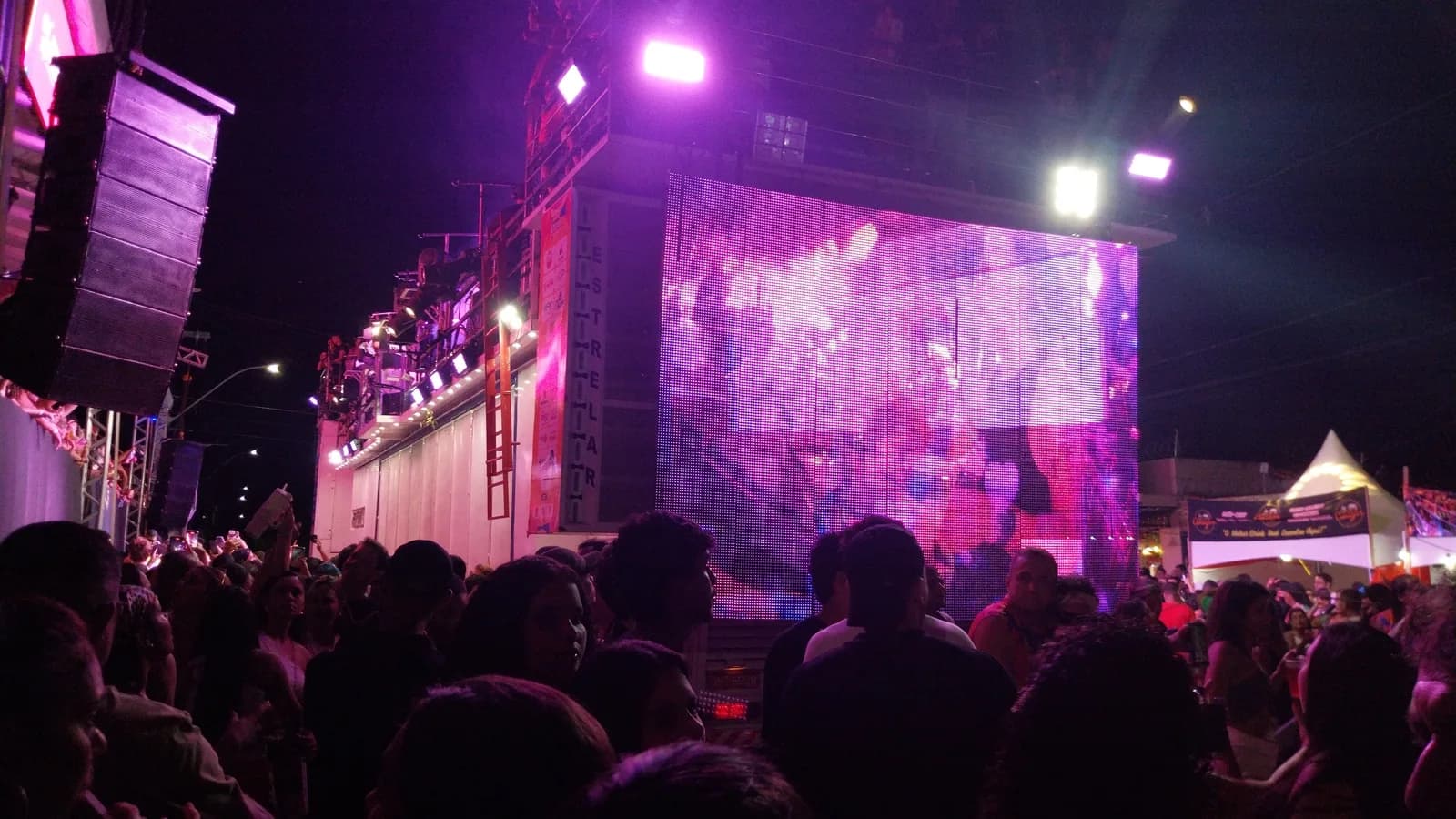 Trio elétrico e multidão em evento de rua à noite (imagem ilustrativa)