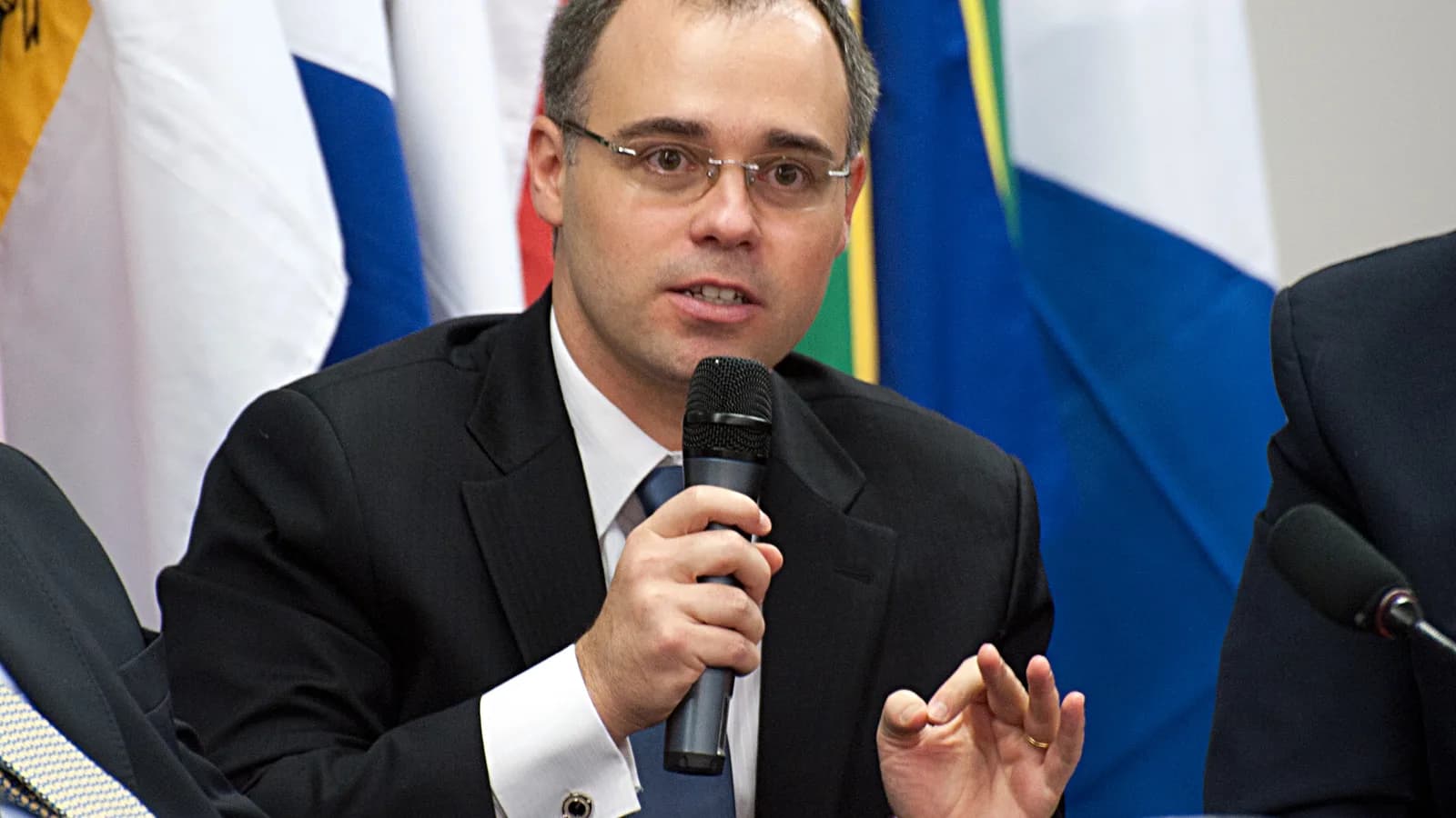 Ministro André Mendonça fala ao microfone em evento institucional