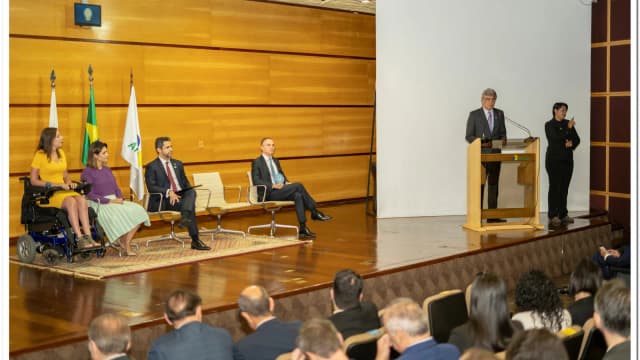 Plateia e mesa de autoridades em evento institucional da Anatel, com logotipo da agência no púlpito