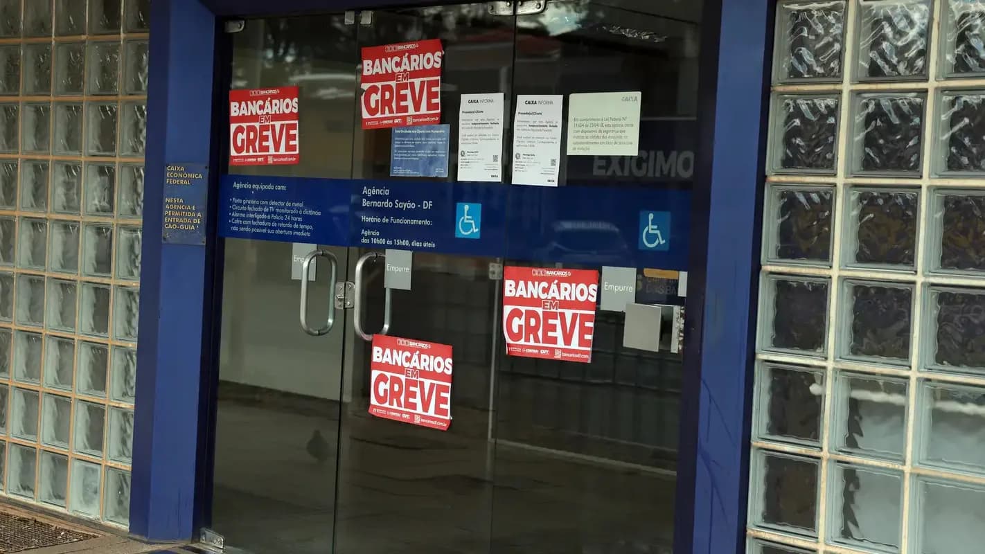 Porta de agência da Caixa Econômica Federal em Brasília com cartazes de 'Bancários em Greve'