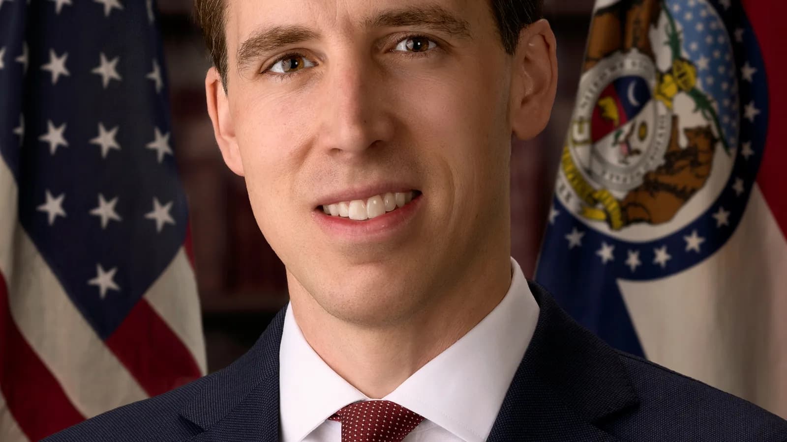 Retrato oficial do senador norte-americano Josh Hawley, com bandeiras dos EUA e do Missouri ao fundo