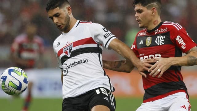 Jogador do São Paulo disputa a bola com jogador do Flamengo durante partida do Campeonato Brasileiro