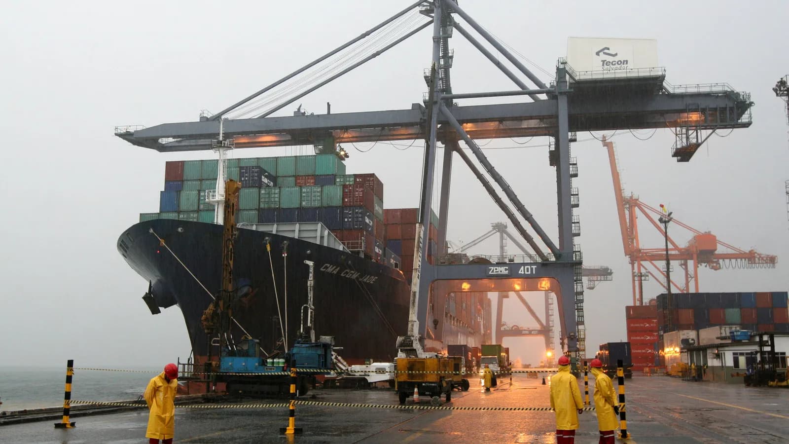 Navio cargueiro é carregado em porto brasileiro, com trabalhadores no cais