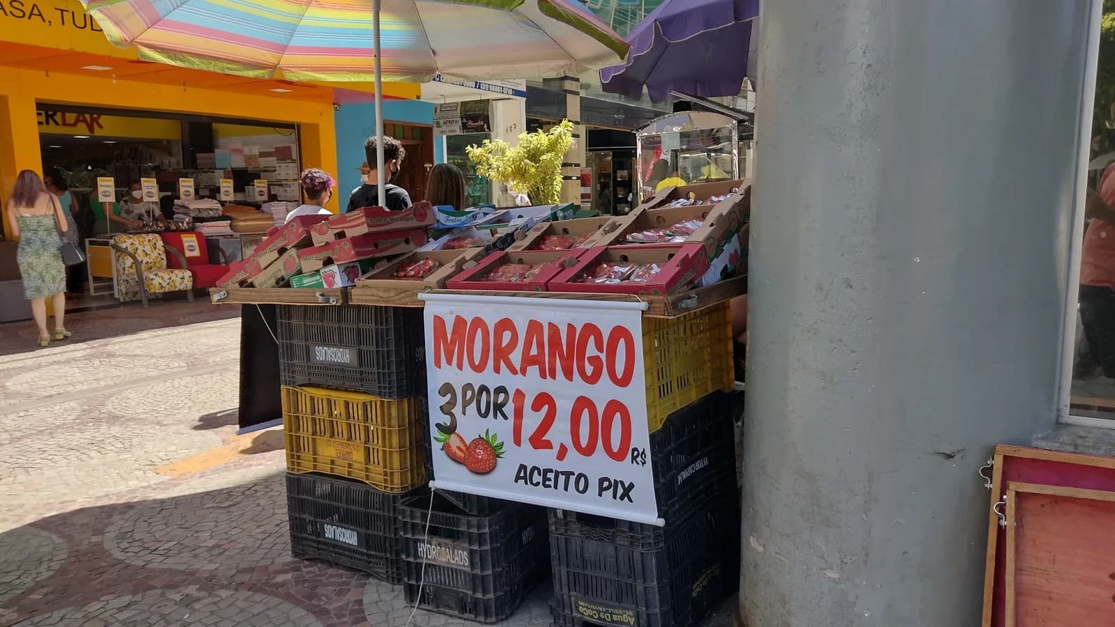 Banca de rua com placa de morango e aviso de que aceita pagamento por Pix