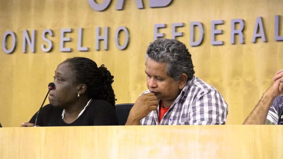 Pessoas em mesa de evento institucional com o letreiro do Conselho Federal da OAB ao fundo