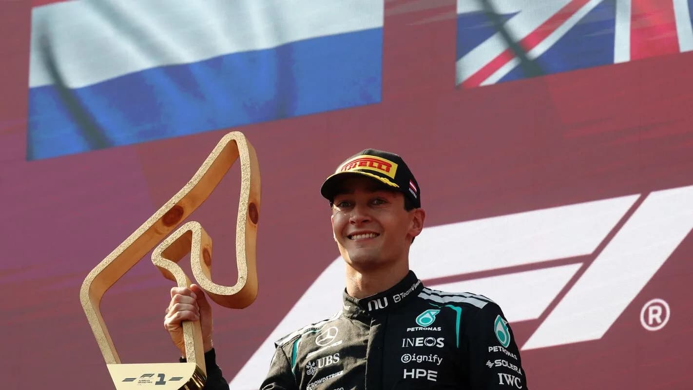 George Russell no pódio da Fórmula 1 segurando troféu, em foto de arquivo de corrida anterior da temporada