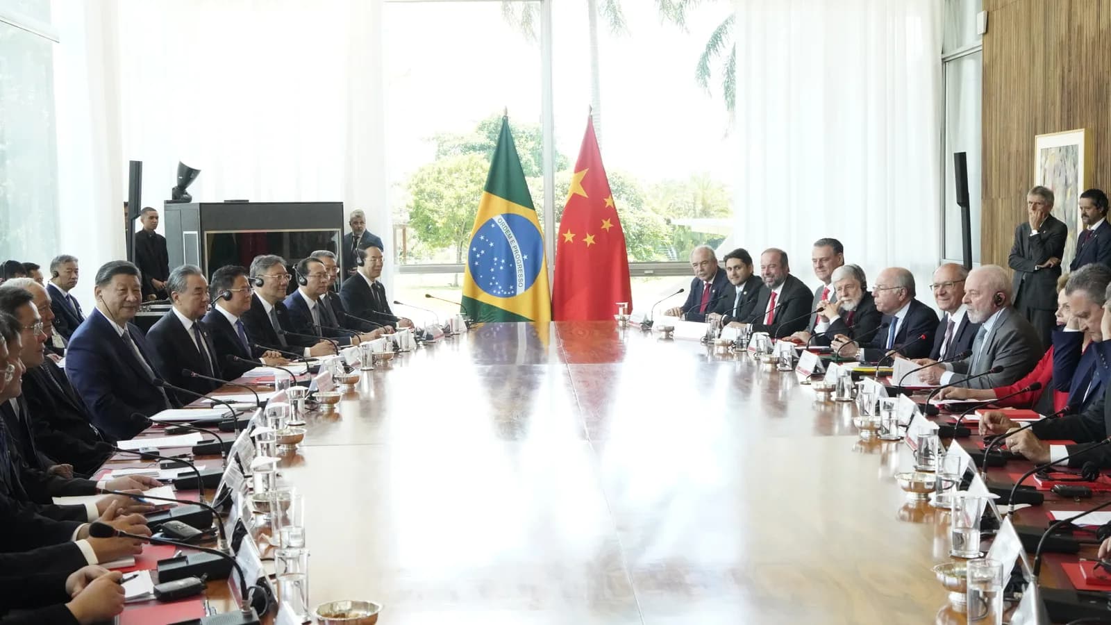 Lula e Xi Jinping em reunião bilateral, com bandeiras do Brasil e da China ao fundo