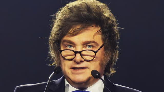 Em foto de arquivo, o presidente da Argentina, Javier Milei, discursa ao microfone, de terno escuro e gravata azul