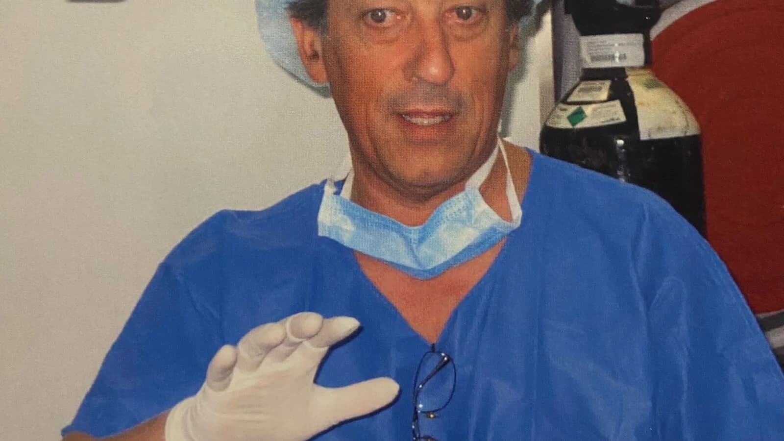 Gastroenterologista em trajes cirúrgicos segurando equipamento de endoscopia