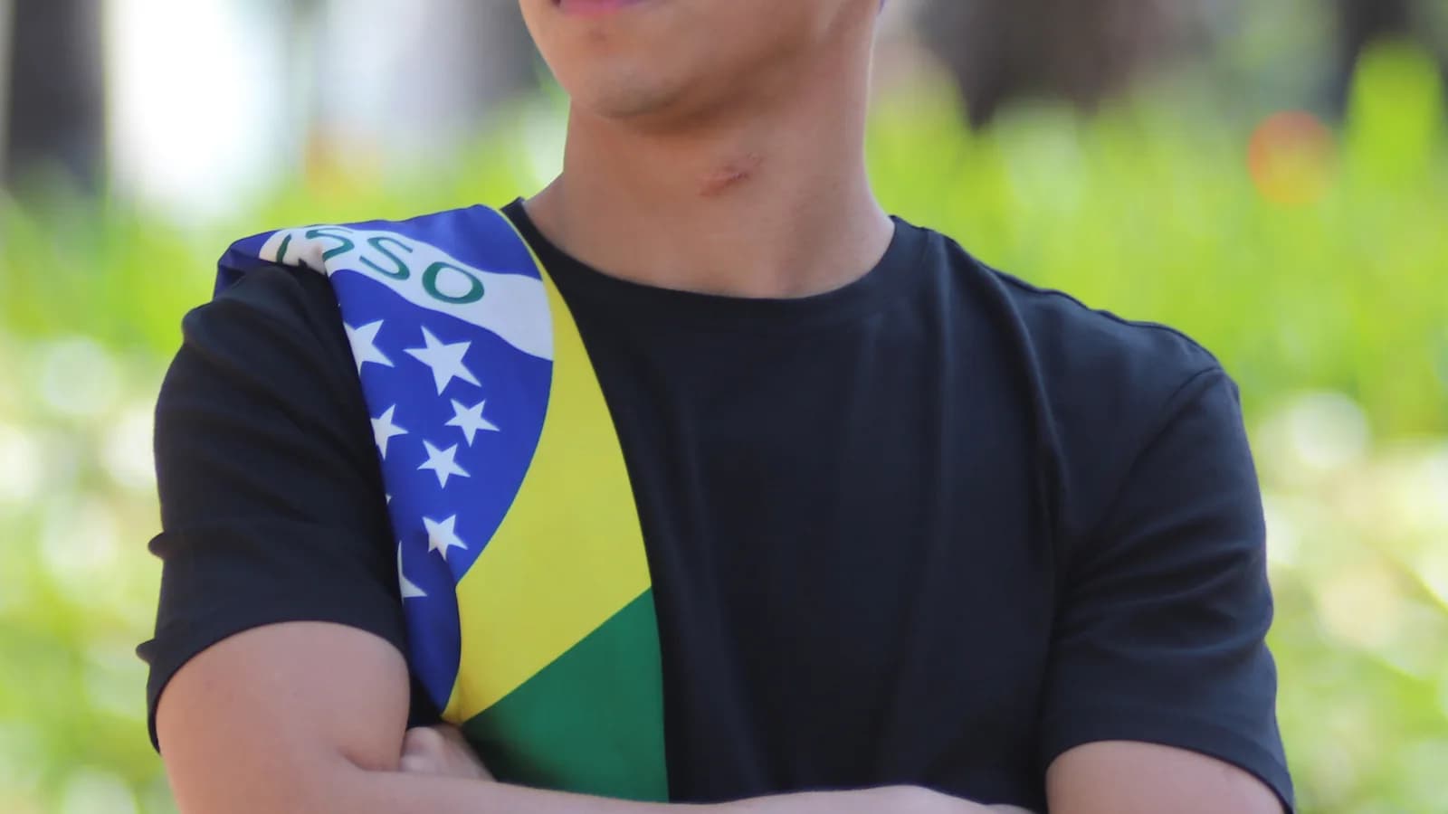 O deputado federal Nikolas Ferreira (PL-MG) em foto ao ar livre com bandeira do Brasil