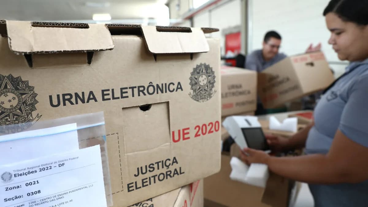 Urna eletrônica em caixa de transporte durante procedimento de carga e lacração da Justiça Eleitoral