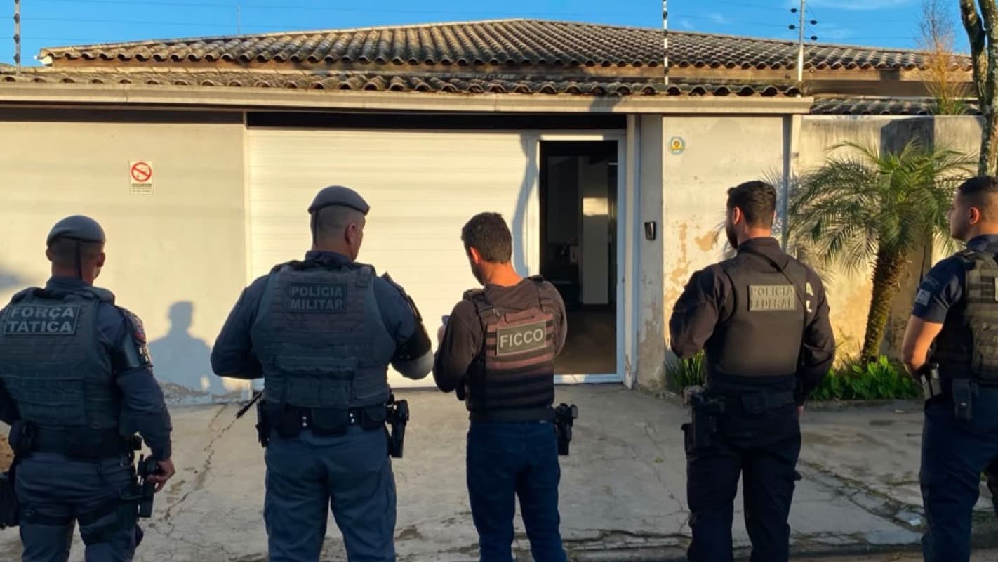Policiais de diferentes forças de segurança em ação durante operação policial em frente a uma casa (imagem de arquivo, ilustrativa de operação policial)