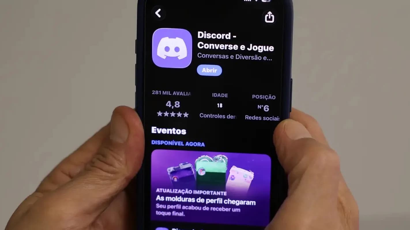 Mãos seguram um smartphone exibindo a página do aplicativo Discord numa loja de apps