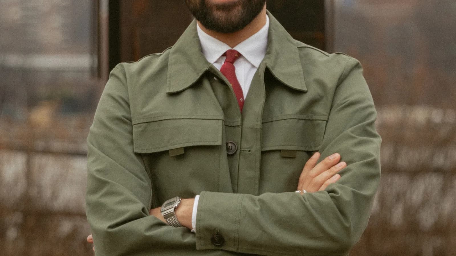 O prefeito de Nova York, Zohran Mamdani, sorrindo com os braços cruzados, com o horizonte da cidade ao fundo