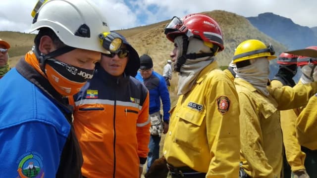Bombeiros equipados combatem incêndio florestal em área de mata