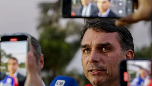 O senador Flávio Bolsonaro (PL) concede entrevista a jornalistas cercado de celulares e microfones