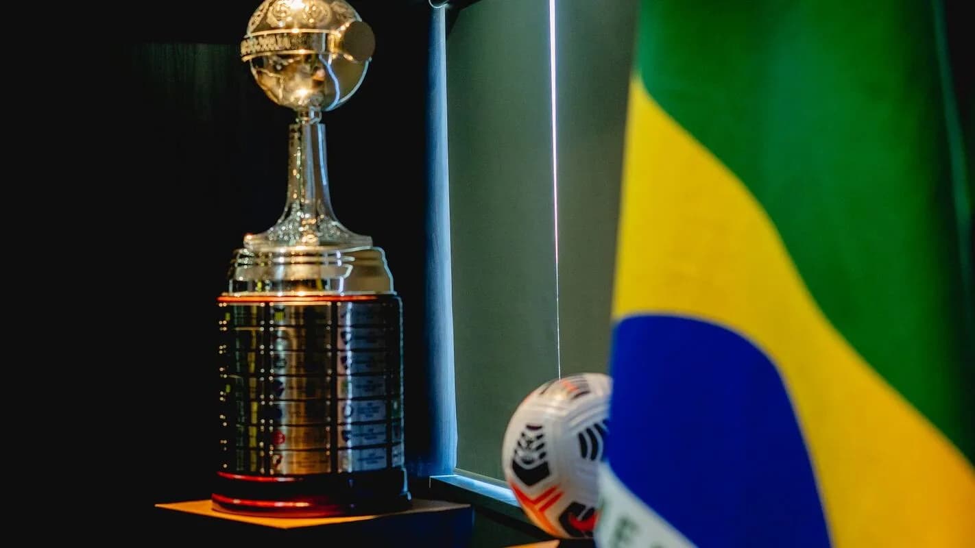 Taça da Conmebol Libertadores ao lado de bandeira do Brasil