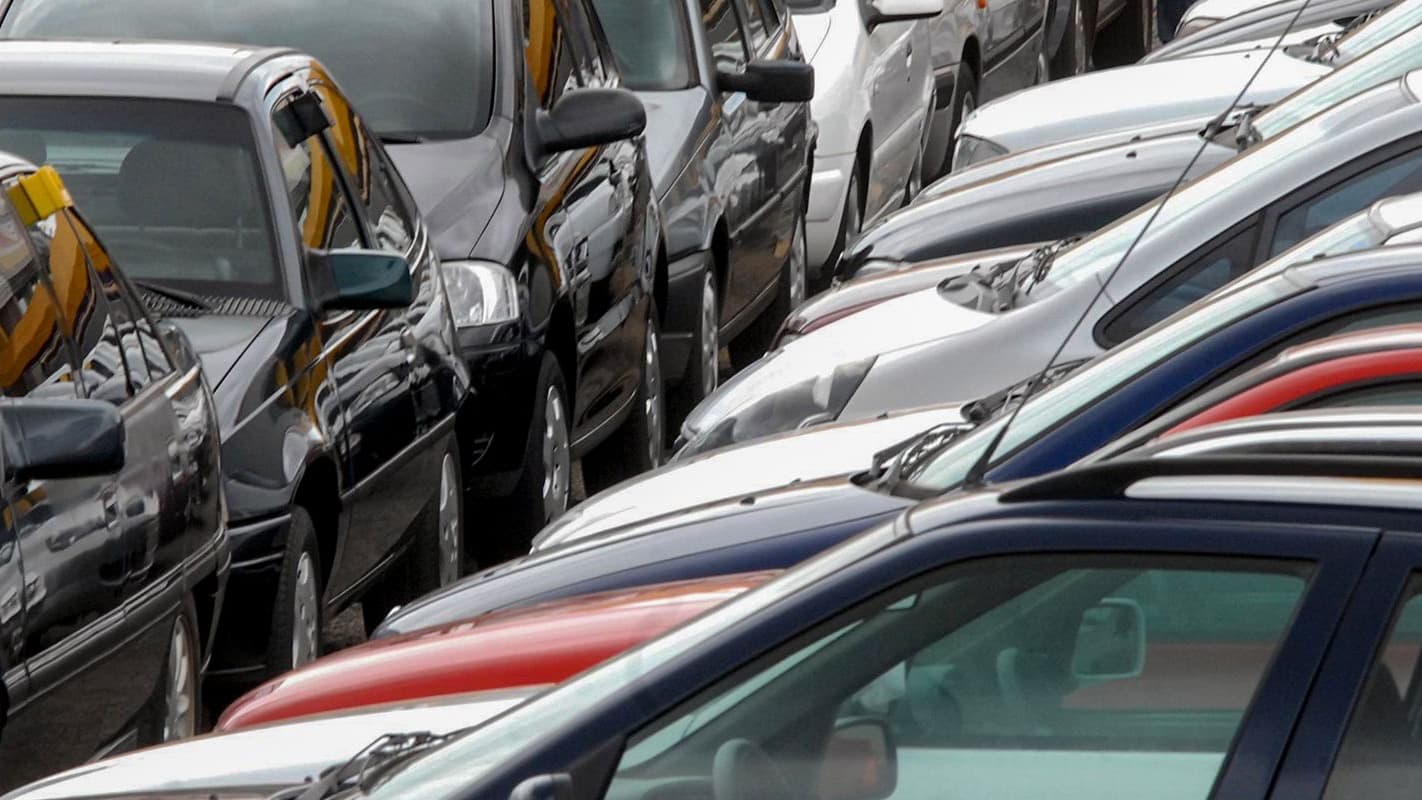 Fileira de carros estacionados lado a lado em pátio, imagem de arquivo