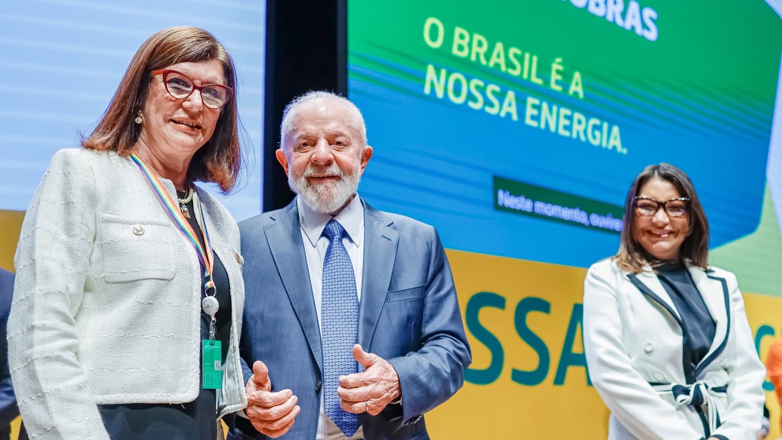 A presidente da Petrobras, Magda Chambriard, ao lado do presidente Lula, sorrindo em evento oficial