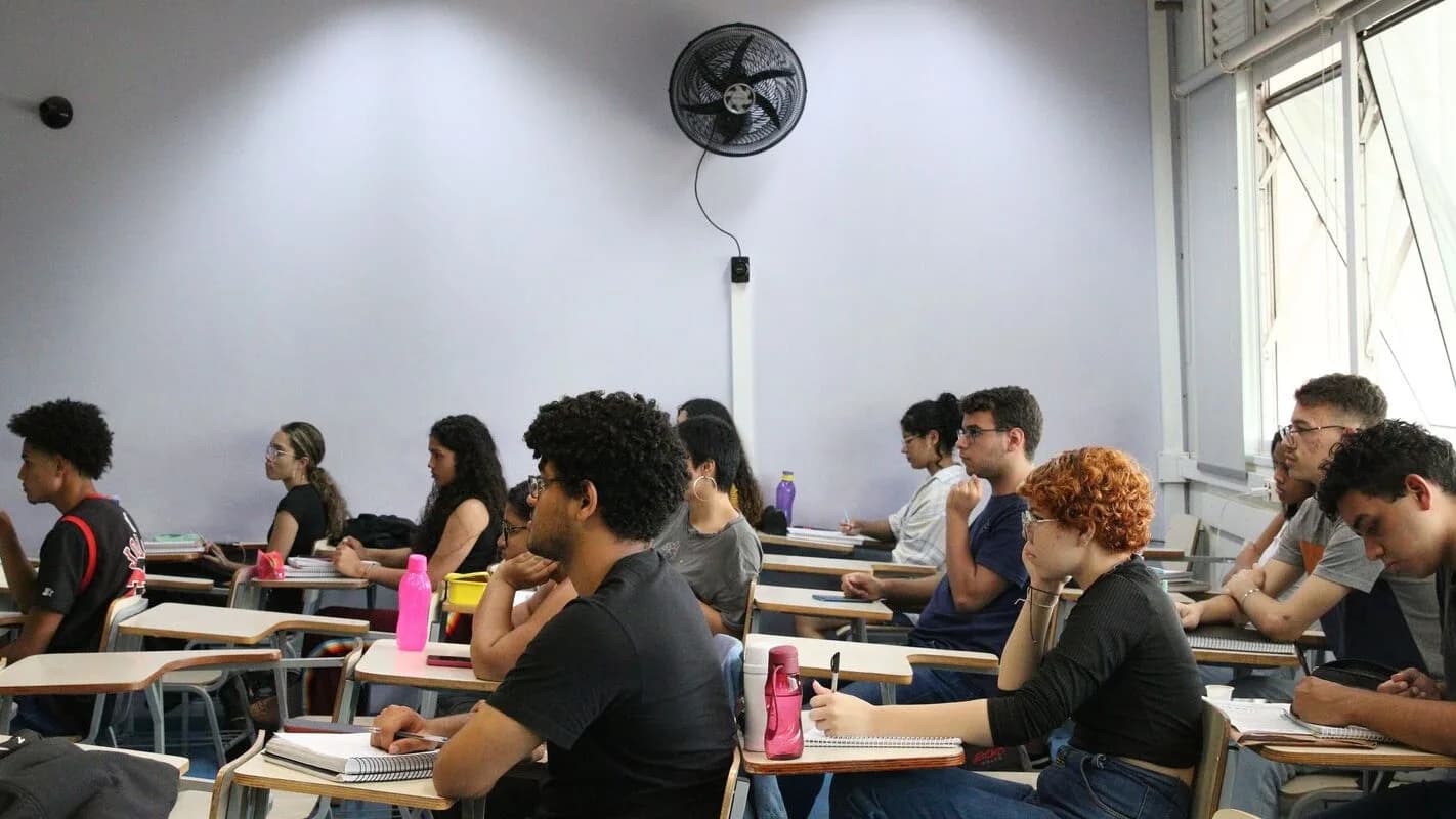 Candidatos sentados em sala de aula durante prova de concurso público