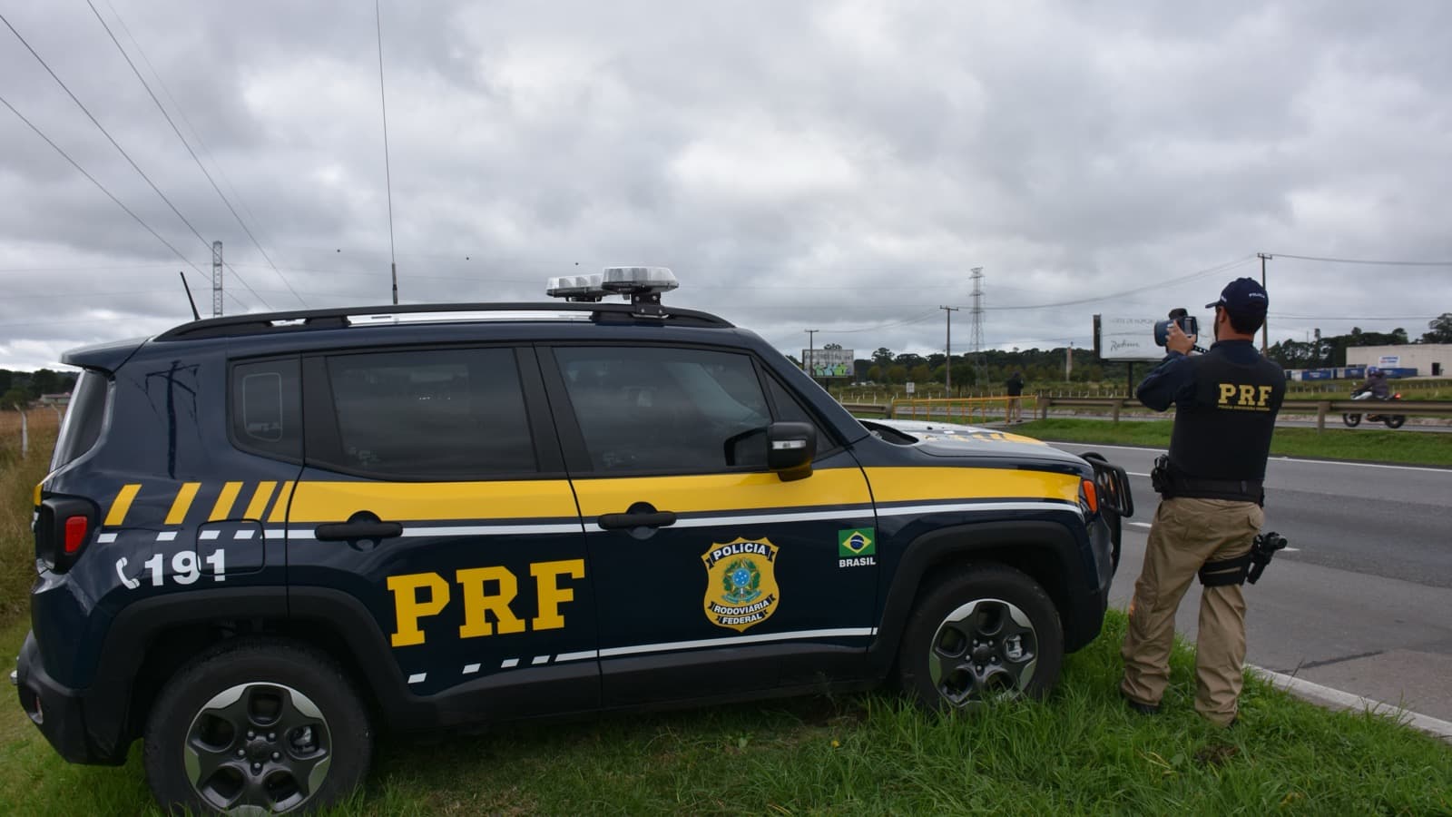 Viatura da Polícia Rodoviária Federal e agente em fiscalização no acostamento de uma rodovia do Paraná (foto de arquivo)