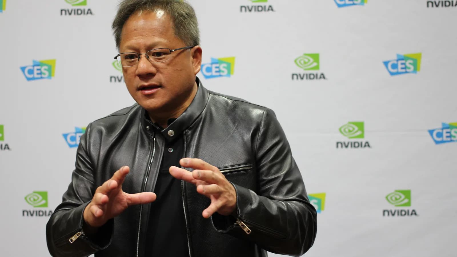 O CEO da Nvidia, Jensen Huang, gesticula durante evento com o logotipo da empresa ao fundo