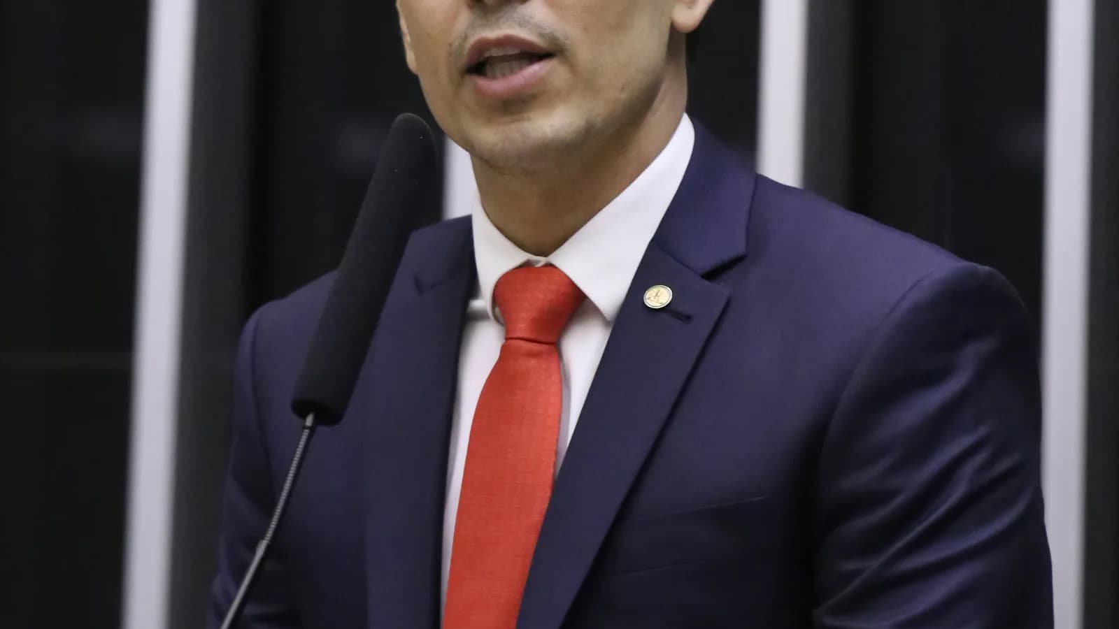 Euclydes Pettersen discursa em plenário da Câmara dos Deputados, de terno escuro e gravata vermelha