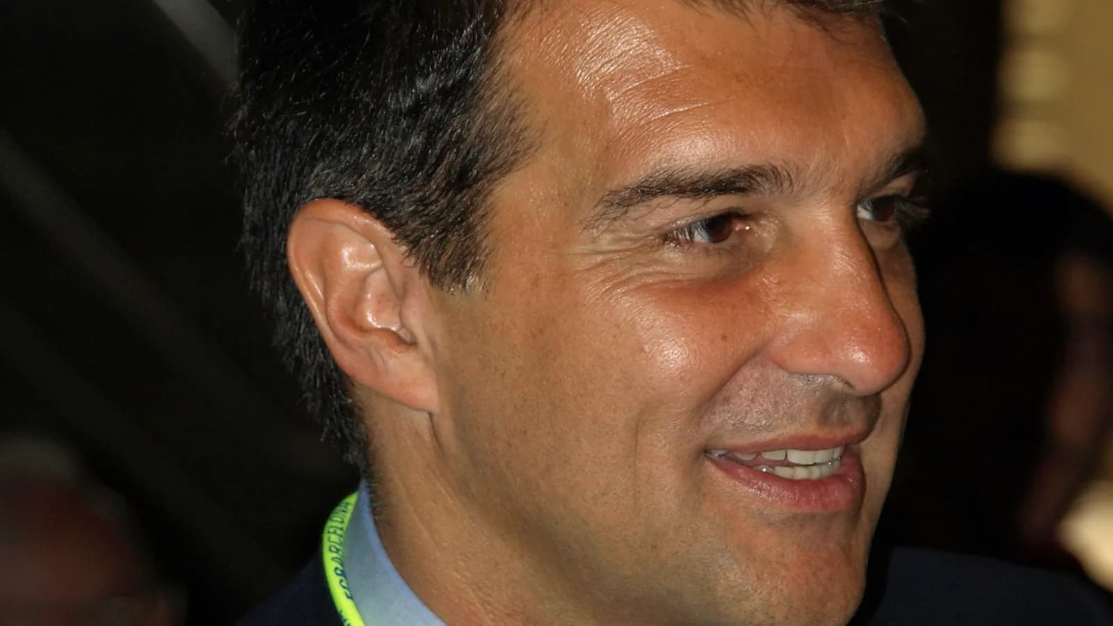 Joan Laporta, presidente do Barcelona, sorri em evento usando crachá do clube
