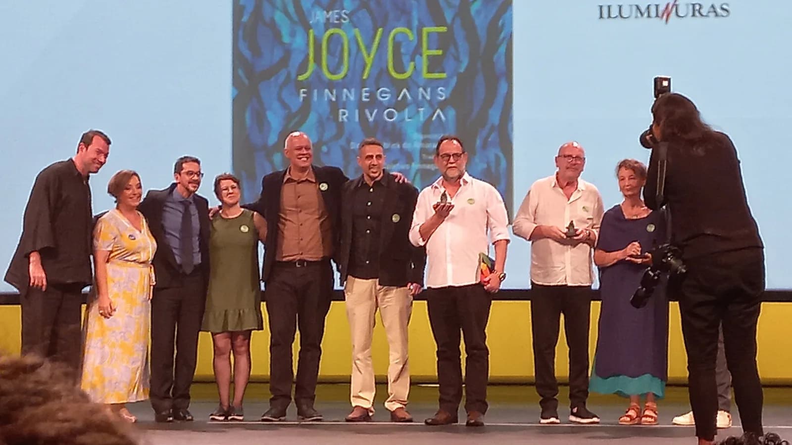Autores premiados seguram troféus no palco de edição anterior do Prêmio Jabuti