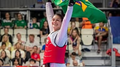 Atleta brasileira de taekwondo comemora com a bandeira do Brasil em competição internacional (foto de arquivo, não é Geovanna Igreja)