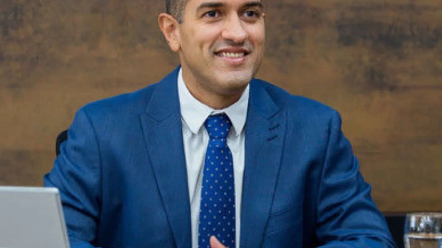 Arthur Henrique, candidato do PL ao governo de Roraima, sorrindo de terno azul durante entrevista
