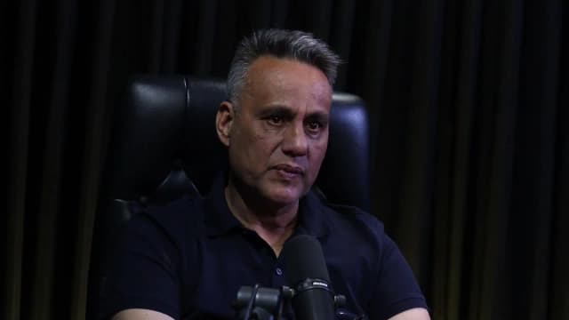 Rogério Furtado com expressão séria durante entrevista ao podcast Encampus, sentado em cadeira de couro preta
