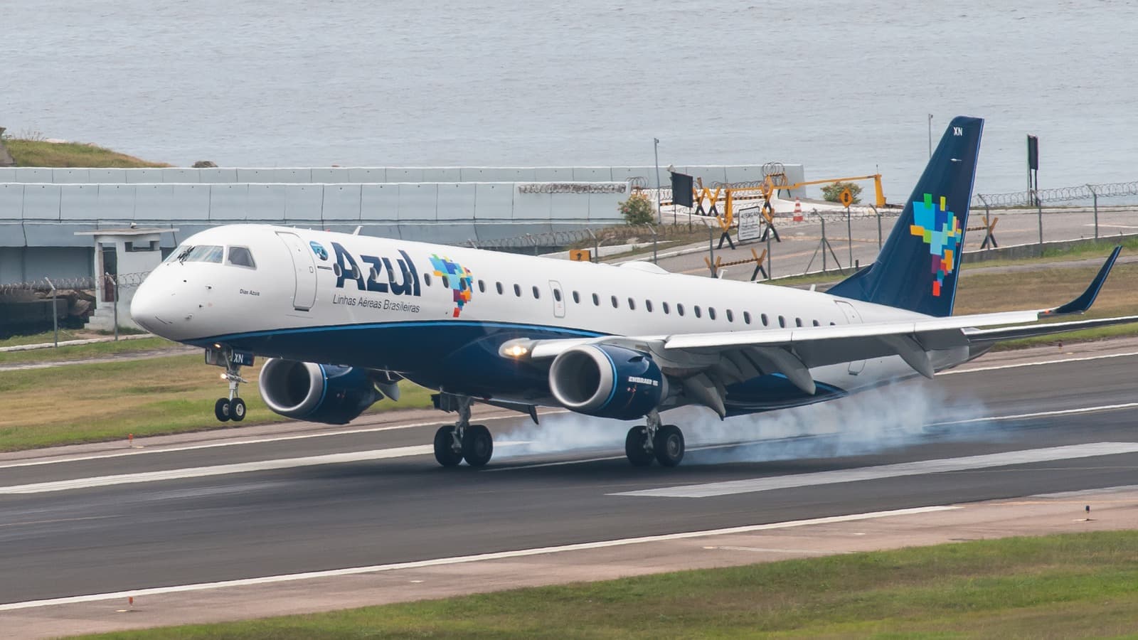 Avião Embraer 195 da Azul toca a pista do Aeroporto Santos Dumont, no Rio de Janeiro, com fumaça nos pneus, em foto de arquivo