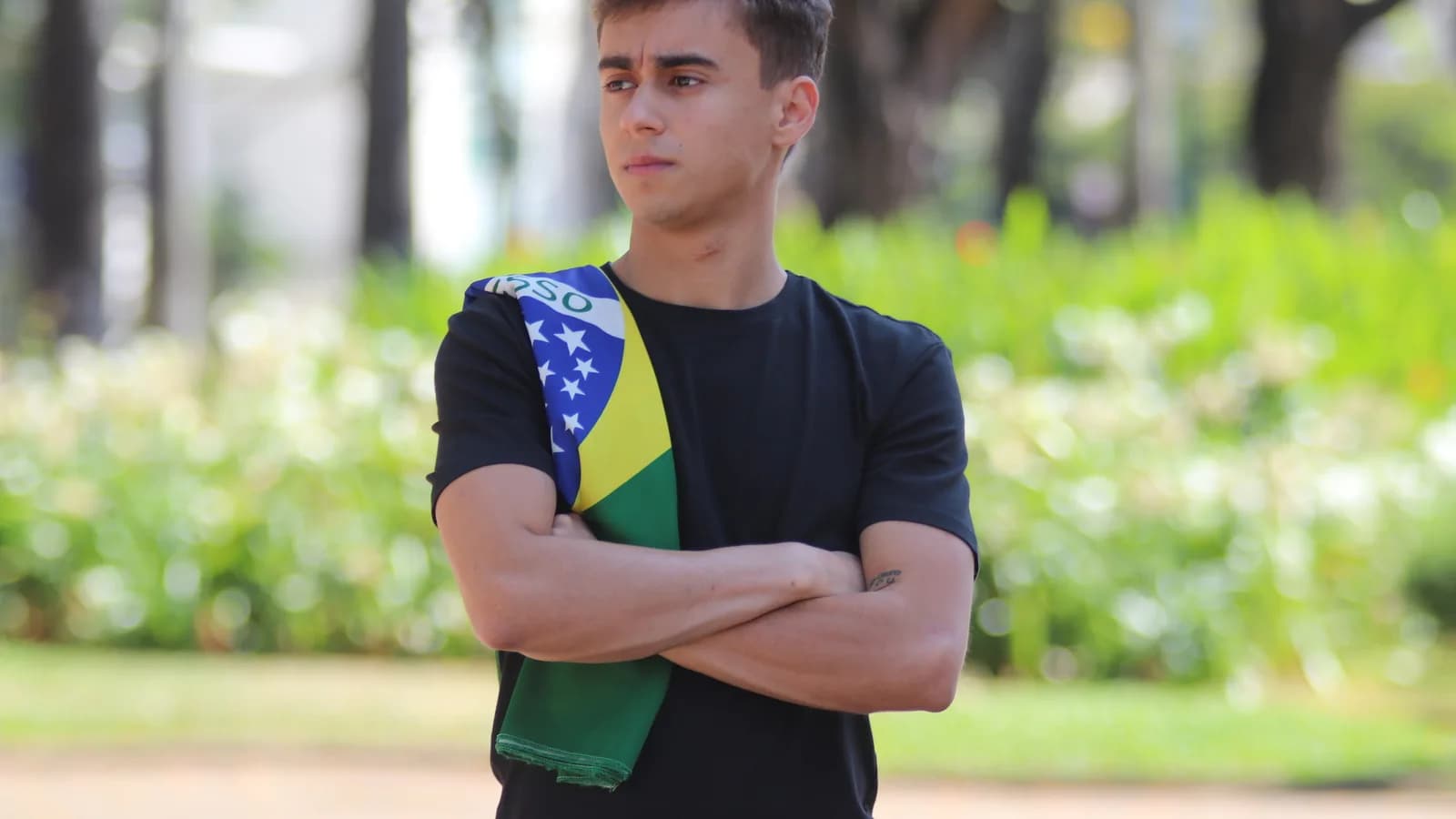 Nikolas Ferreira em fotografia de arquivo de 2020, com bandeira do Brasil sobre o ombro