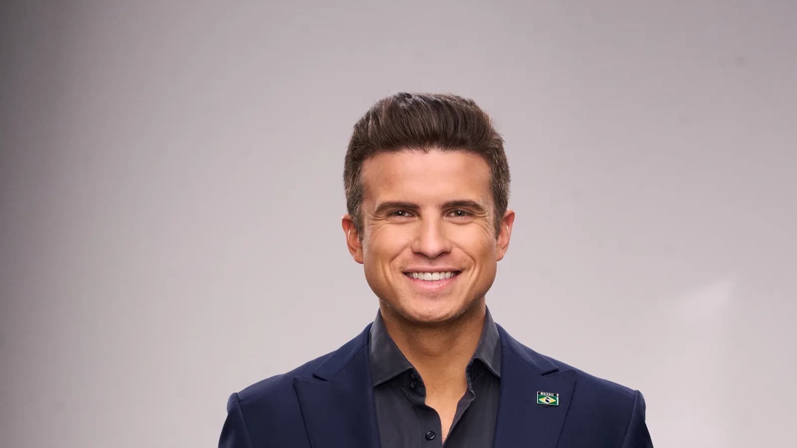 Retrato oficial de André Marinho, candidato do Novo ao governo do Rio de Janeiro, sorrindo de terno azul-marinho