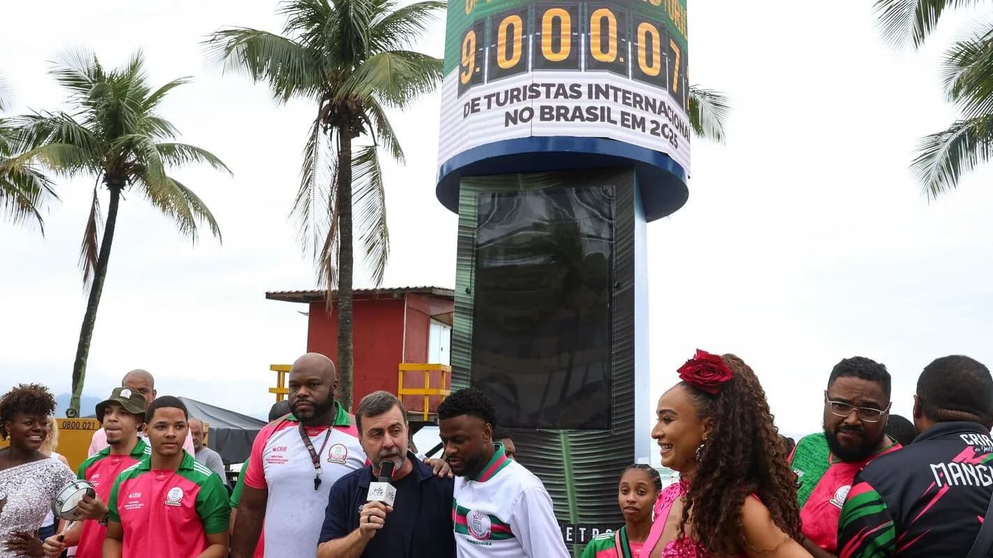 Público reunido em frente a totem comemorativo de recorde de turistas internacionais em Copacabana, Rio de Janeiro