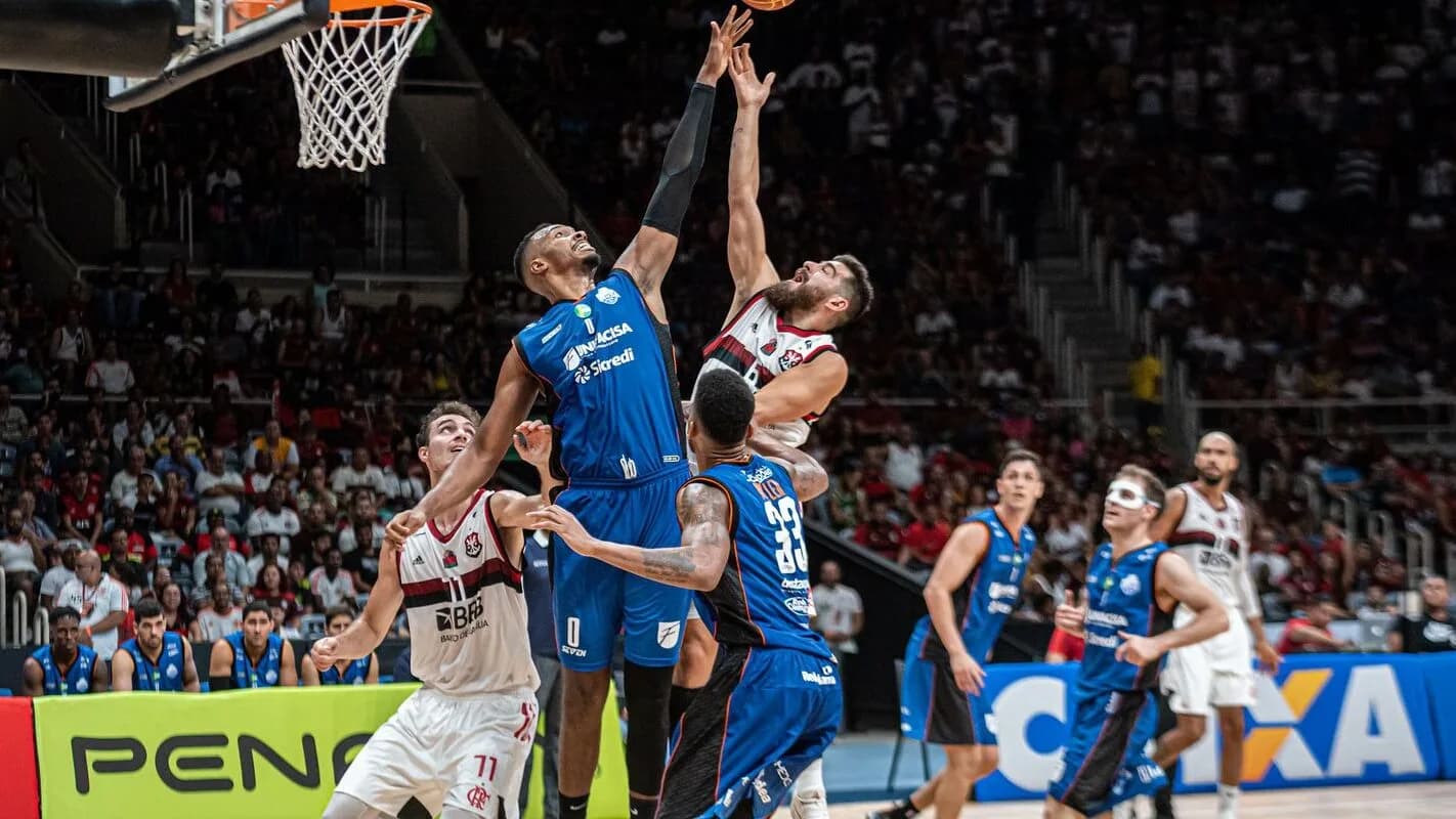 Jogadores disputam bola sob a cesta em partida de basquete (foto de arquivo/contexto)