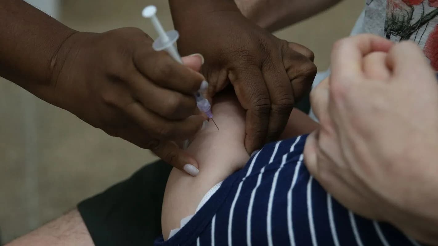 Profissional de saúde aplica cuidado em criança, foto de arquivo hospitalar