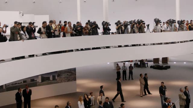 Interior do Museu Nacional da República, em Brasília, com visitantes e fotógrafos reunidos sob o teto em forma de disco