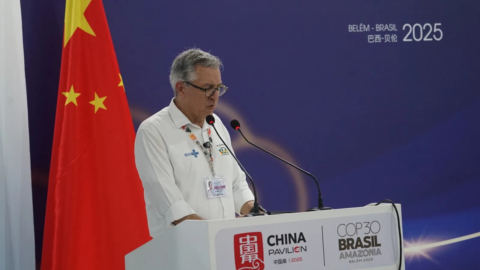 Alexandre Padilha discursa em púlpito com bandeiras do Brasil e da China ao fundo, em foto de arquivo da COP30