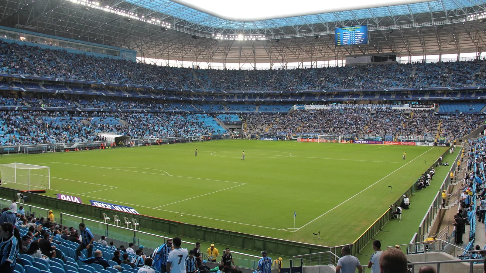 Arena do Grêmio com jogo em andamento, arquibancadas lotadas