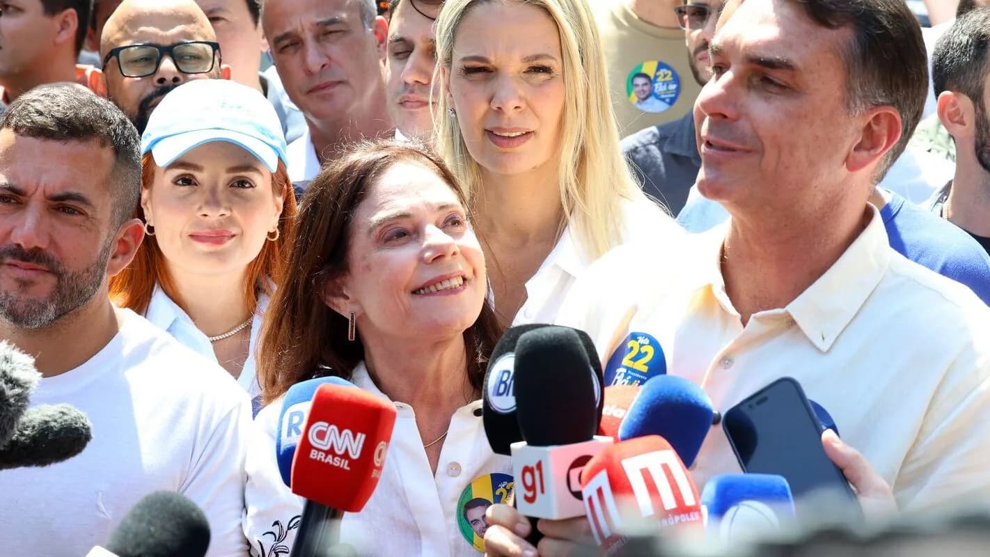 O senador Flávio Bolsonaro cercado de microfones de emissoras de TV durante entrevista coletiva à imprensa