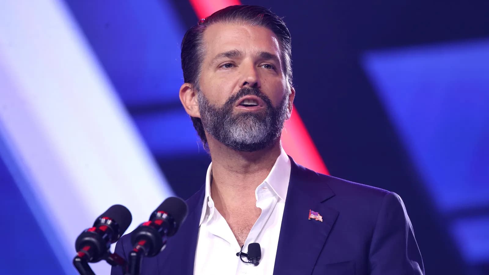Donald Trump Jr. discursa em microfones de podium durante evento conservador