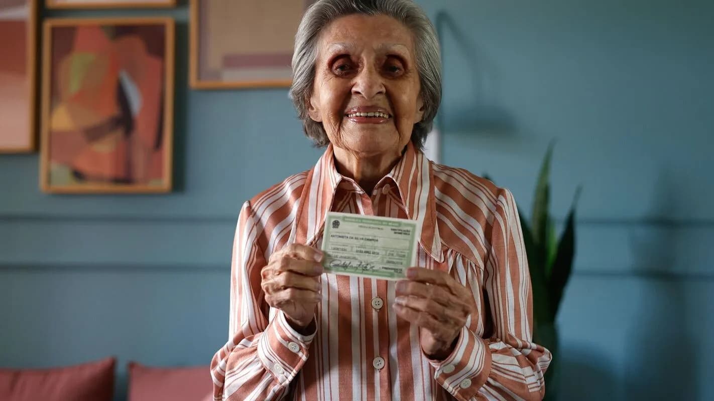 Eleitora idosa sorri ao mostrar o título de eleitor (foto de arquivo)