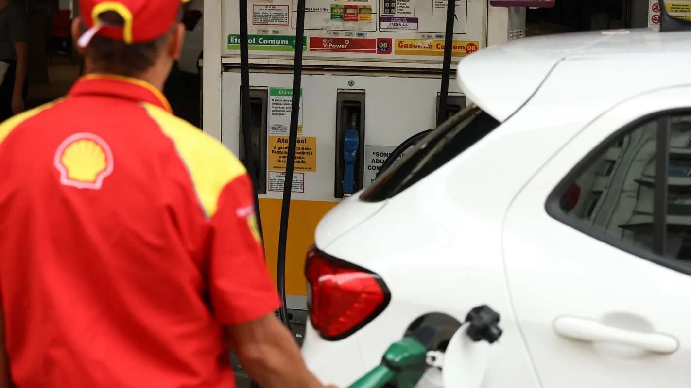Frentista da Shell abastece carro em posto de combustível no Brasil