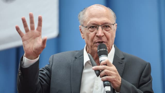 Foto de arquivo: o vice-presidente Geraldo Alckmin, de terno escuro e óculos, fala ao microfone com a mão direita erguida durante evento em São Paulo