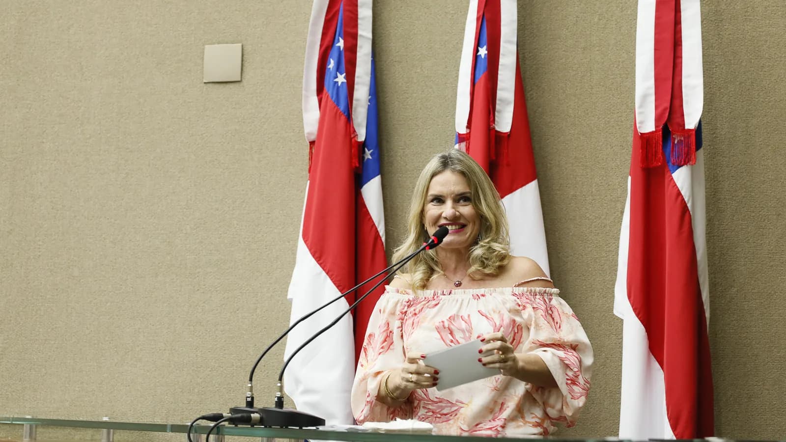 Ivana Bastos discursa no plenário da Assembleia Legislativa da Bahia, com bandeiras ao fundo
