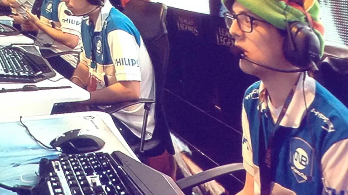 Jogadores de League of Legends competem em evento de e-sports, usando fones de ouvido e uniformes de equipe